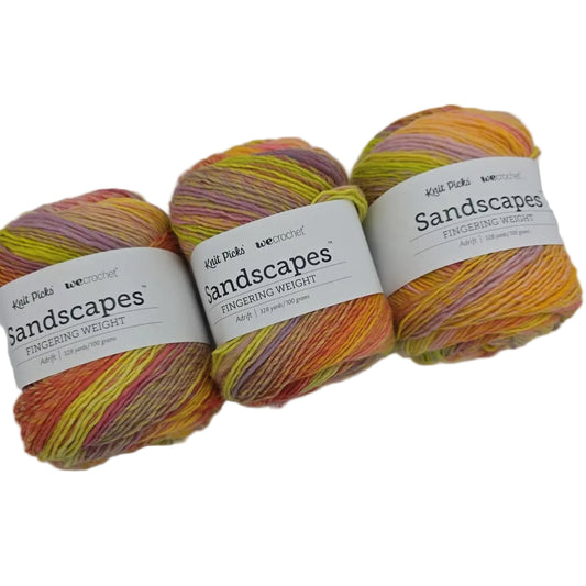 Image of 3 cakes of Knit Picks Sandscapes in the color Adrift with labels on a white background.