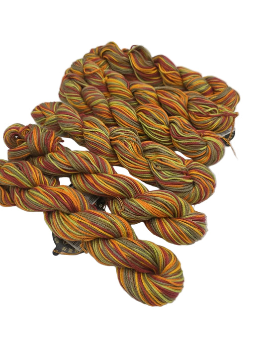 6 skeins of Lily Multi Yarn by Noro in color 119 Fruit Salad on a white background.