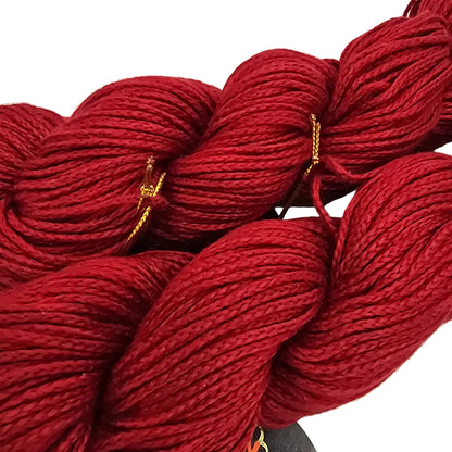 Close-up image of Two Skeins of red lily by Noro Yarn in Color 24 with label on a white background.