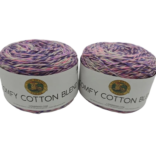 Image of two cakes of Lion Brand Comfy Cotton Blend yarn in the color Soothing Lavender with labels on a white background.