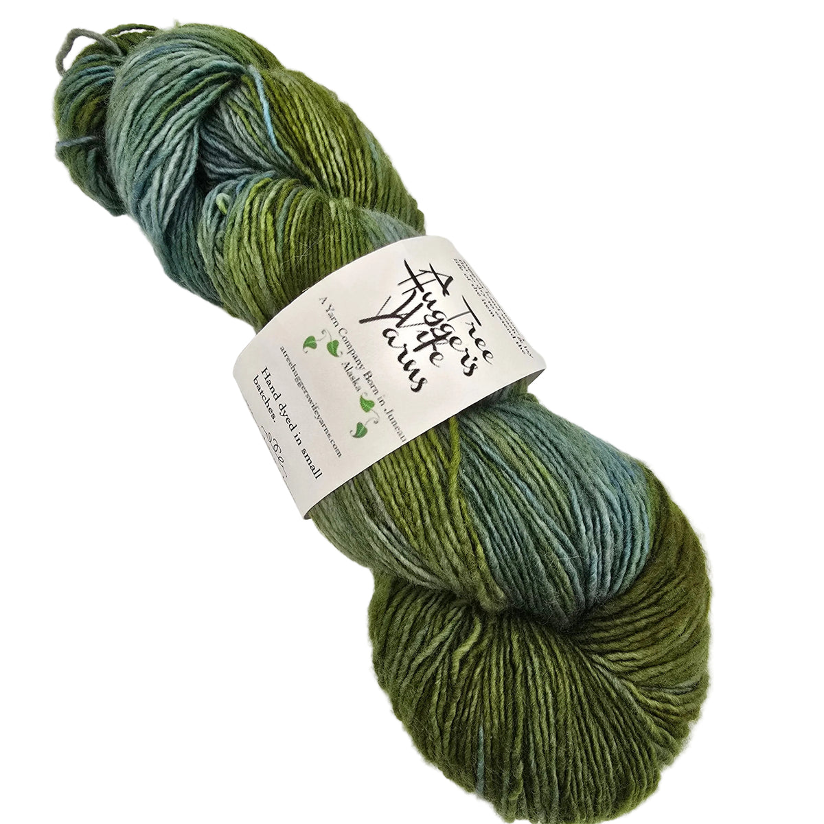 A skein of variegated yarn in shades of olive green and teal-blue, wrapped with a white paper label that reads 'A Tree Hugger's Wife yarns'.