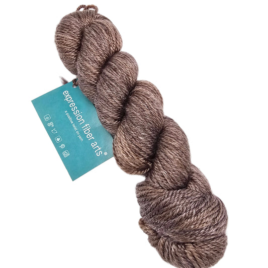 Image of a single skein of Luster_Worsted_Yarn by_Expression_Fiber_Arts in the color Brocade a slightly shimmery brown with label on a white background.