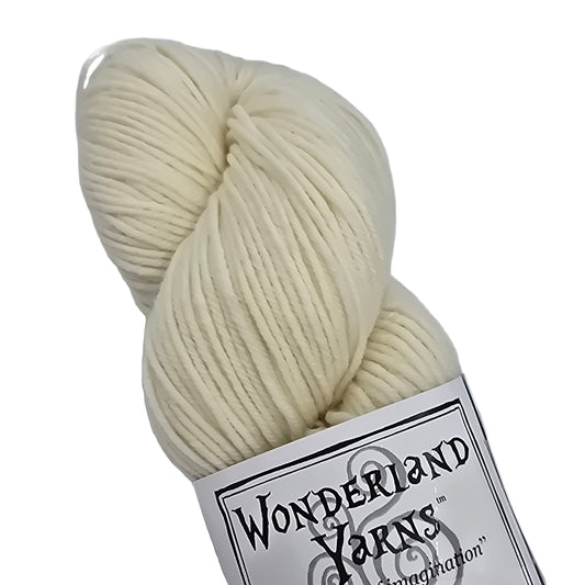 Image of a single skein of Mad Hatter by Wonderland Yarns in the color white rabbit which is a cream with a label on a white background.