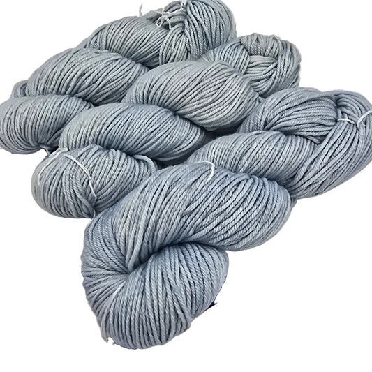Image of three skeins of yarn by the brand malabrigos in the color cosmos which is a solid light blue on a white background.