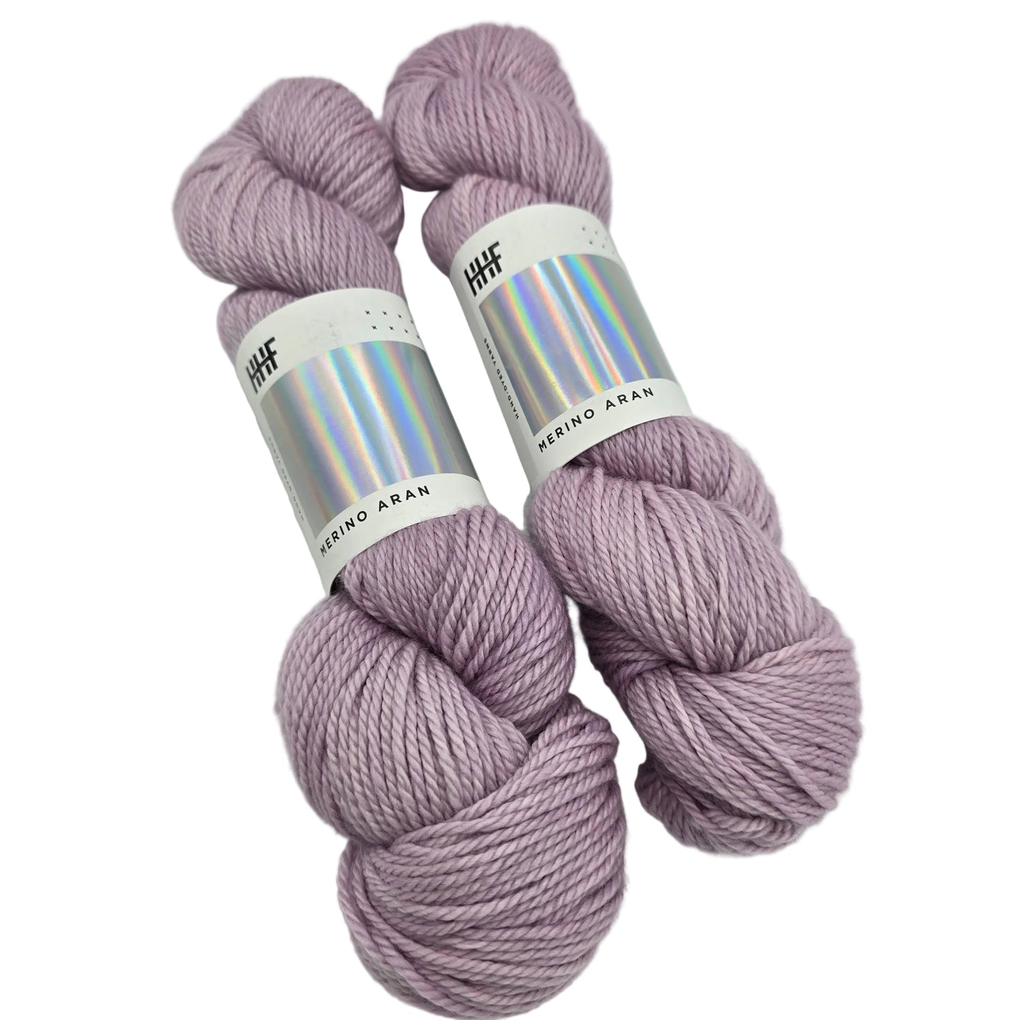 Image of two hanks of Merino Aran Yarn by Hedgehog Fibres in the color Ghost with labels on a white background.