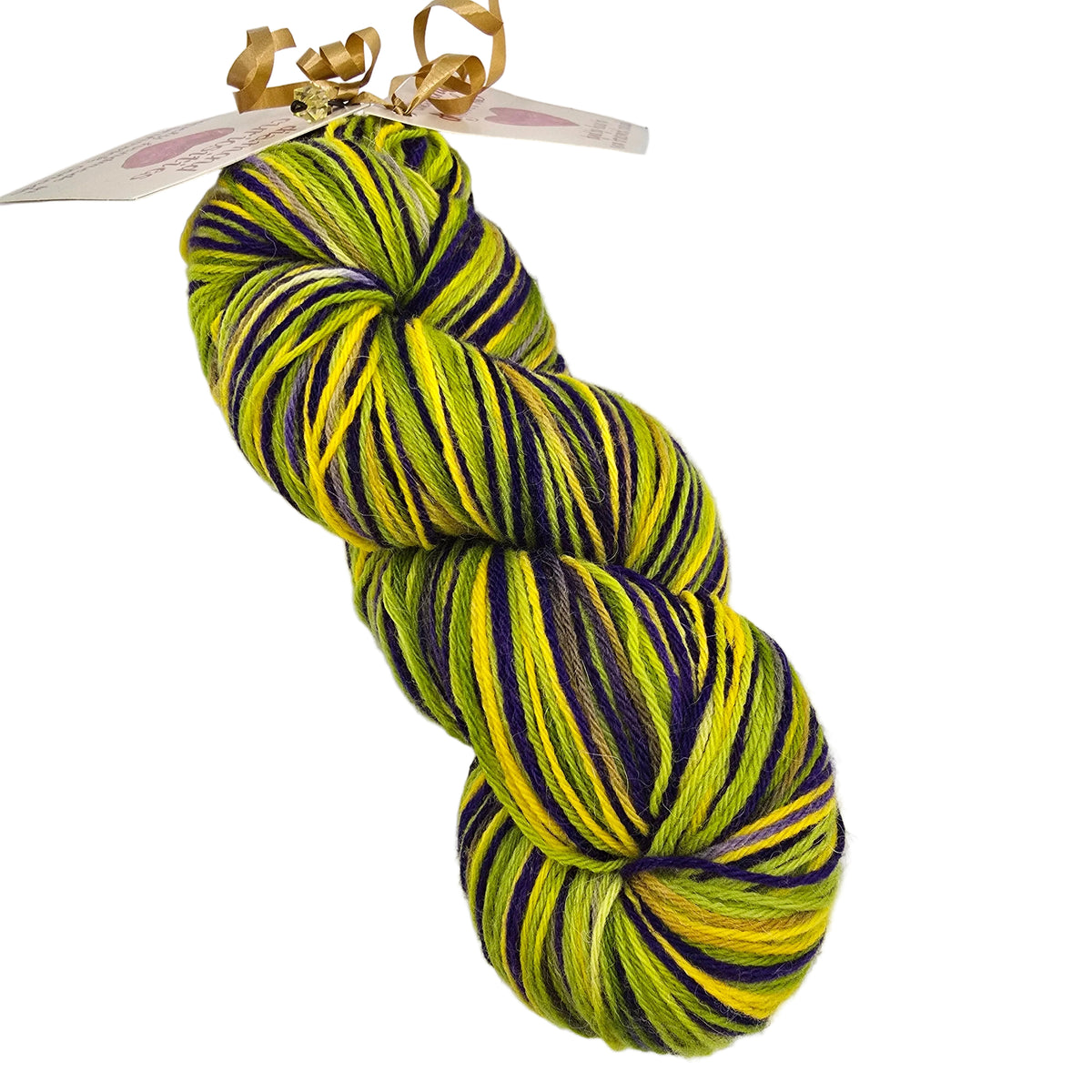 A single skein of variegated yarn with bright yellow, lime green, and dark purple stripes, attached to a paper tag with a gold ribbon, on a plain white background.