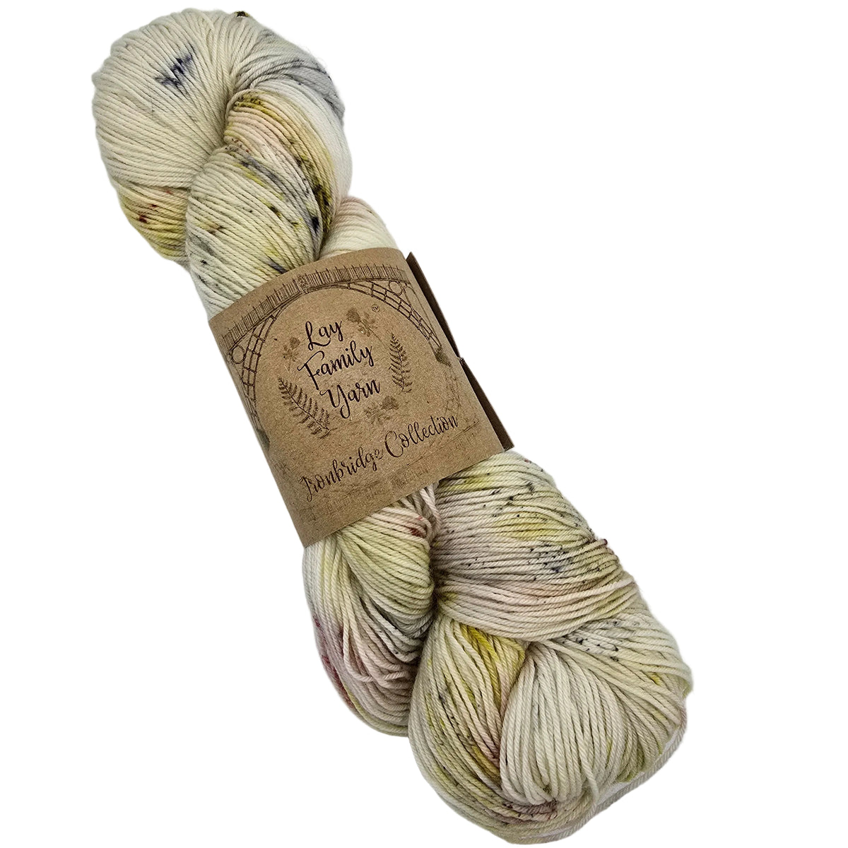 A skein of variegated  Merino Nylon Light Fingering yarn by Lay Family Yarn featuring cream, beige, and light yellow fibers with subtle dark speckles, wrapped in a brown kraft paper label.