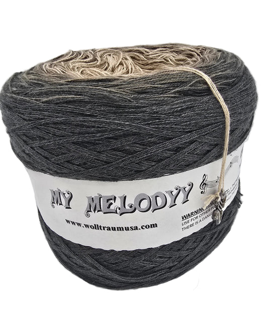 A cake of variegated charcoal gray and beige yarn with a white paper label on a white background.