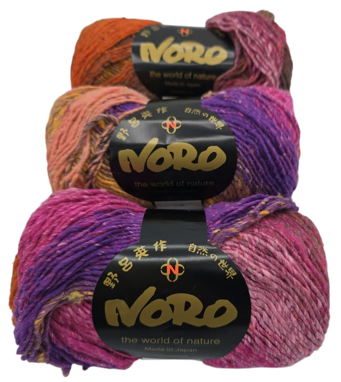 Three skeins of multicolor pink, orange, and purple Noro Brand Taiyo yarn with Noro Brand Labels on a white background.