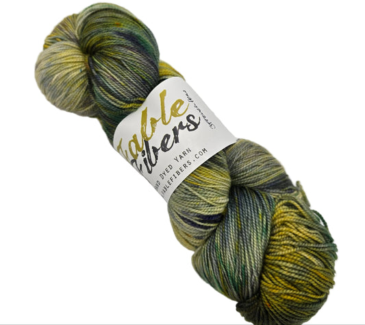 Image of a single skein of NovelYarn by Fable Fibers in the color 3 French Hens with label on a white background.