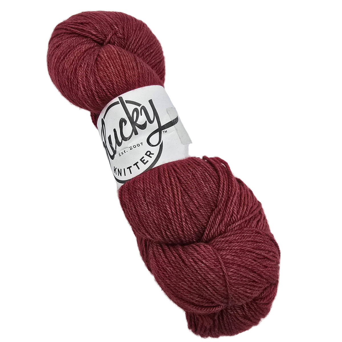 A skein of Oxford_yarn by_Plucky_Knitter_in the color_Hudson a burgundy yarn with a white paper label on a white background.