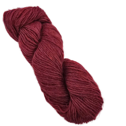 A single skein of Peruvia_by_Berroco yarn in color  7135 twisted yarn in a deep burgundy red color, photographed on a clean white background.