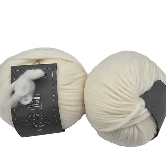 Image of two balls of Piuma by DHG Ultra Soft bulky Italian Merino Wool  yarn in the color Natural White which is a solid off-white with labels on a white background
