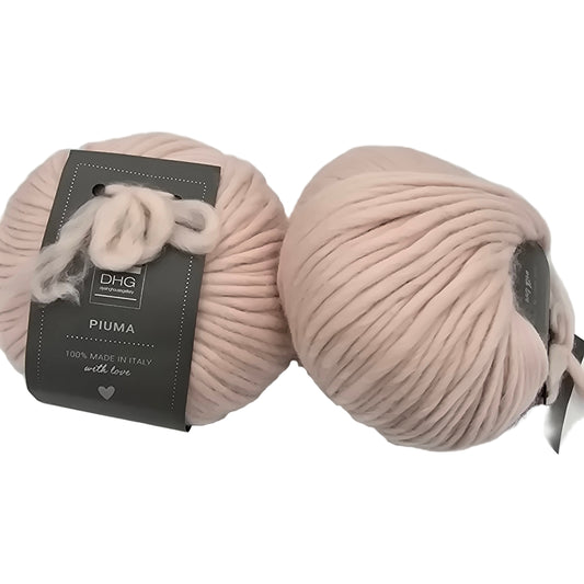 Image of two balls of Piuma by DHG Ultra Soft bulky Italian Merino Wool  yarn in the color Etoile which is a solid very pale pinky beige with labels on a white background