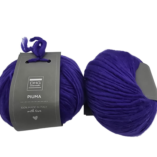 Image of two balls of Piuma by DHG Ultra Soft bulky Italian Merino Wool  yarn in the color Florence which is a solid vibrant purple with labels on a white background