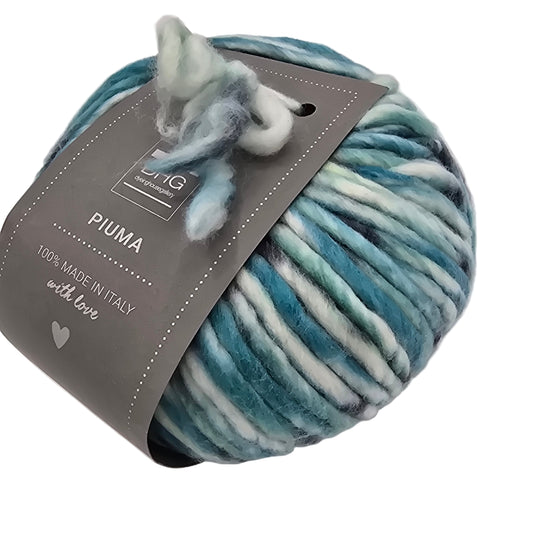 Image of single ball of Piuma by DHG Ultra Soft, bulky, Italian, Merino Wool  yarn in the color Highalnd which is a multicolor yarn with mixed blues and black on a white base with labels on a white background.