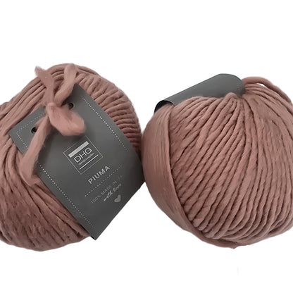 Image of two balls of Piuma by DHG Ultra Soft bulky Italian Merino Wool  yarn in the color Lace which is a solid Mauve with labels on a white background