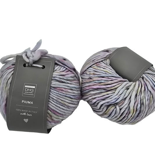 Image of two balls of Piuma by DHG Ultra Soft, bulky, Italian, Merino Wool  yarn in the color Little Mermaid which is a multicolor yarn with mixed pastel colors on a lavender base with labels on a white background.