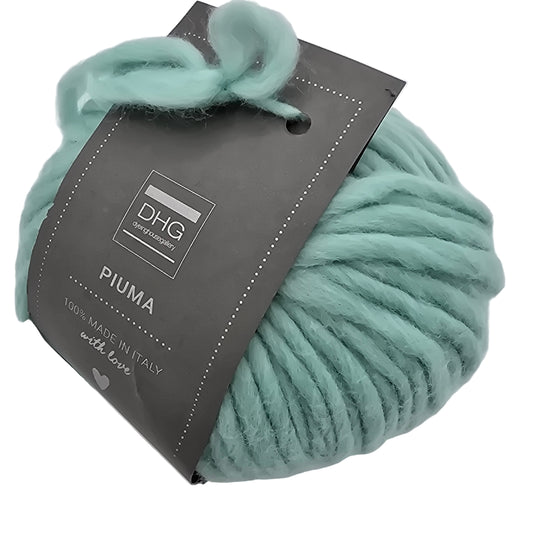 Image of single ball of Piuma by DHG Ultra Soft, bulky, Italian, Merino Wool  yarn in the color Paradise which is a solid light turquoise with label on a white background.