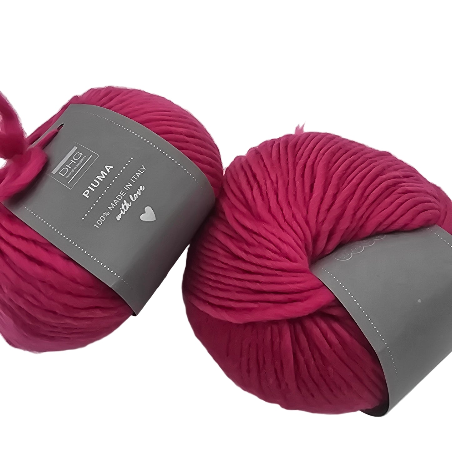 Image of two balls of Piuma by DHG Ultra Soft bulky Italian Merino Wool  yarn in the color Raspberry which is a solid dark pink with labels on a white background.