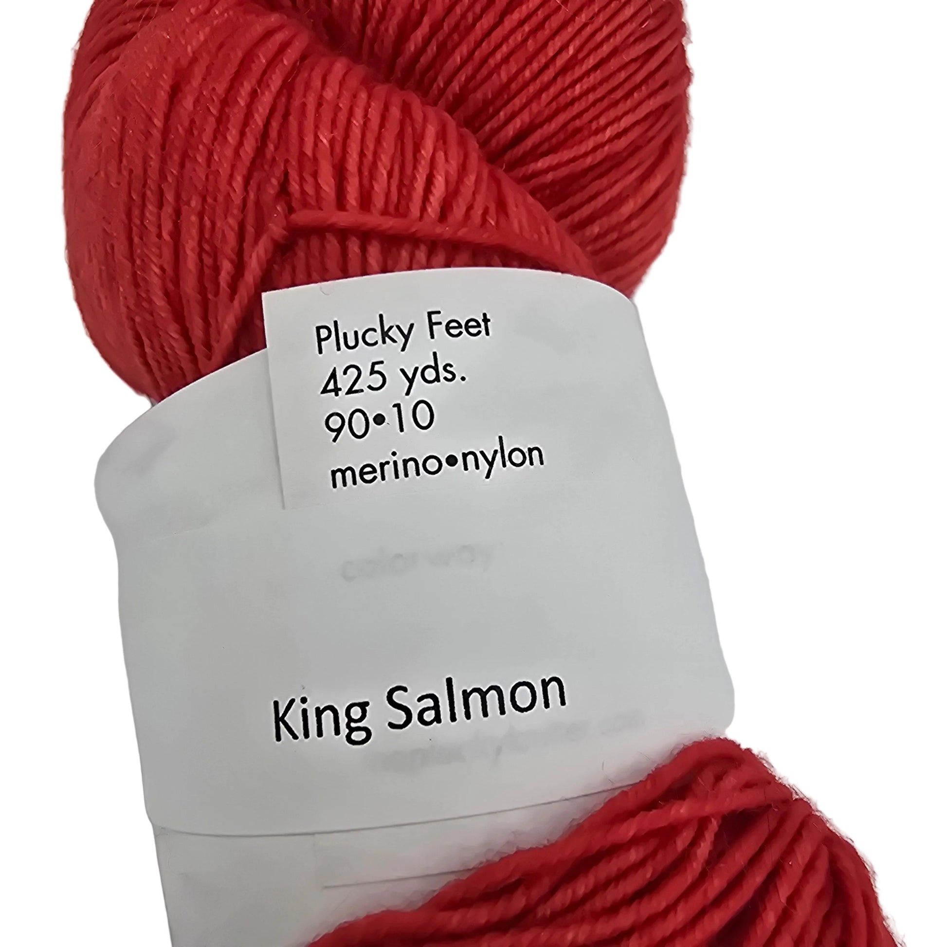 Close-up image of the label of a single skein of Plucky Feet by Plucky knitter Merino-Nylon blend yarn in color King Salmon which is red, on white background.