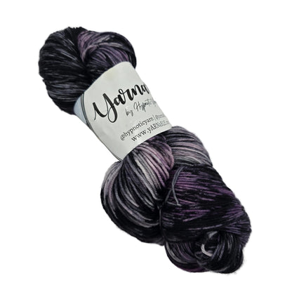 Image of a single hank of Plush Sock yarn by Hypnotic Yarn in the color Storm Watch with label on a white background.