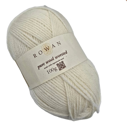 A skein of cream-colored Pure_Wool_Superwash_Worsted yarn_by_Rowan_in_Color_00101 with a paper label on a white background.