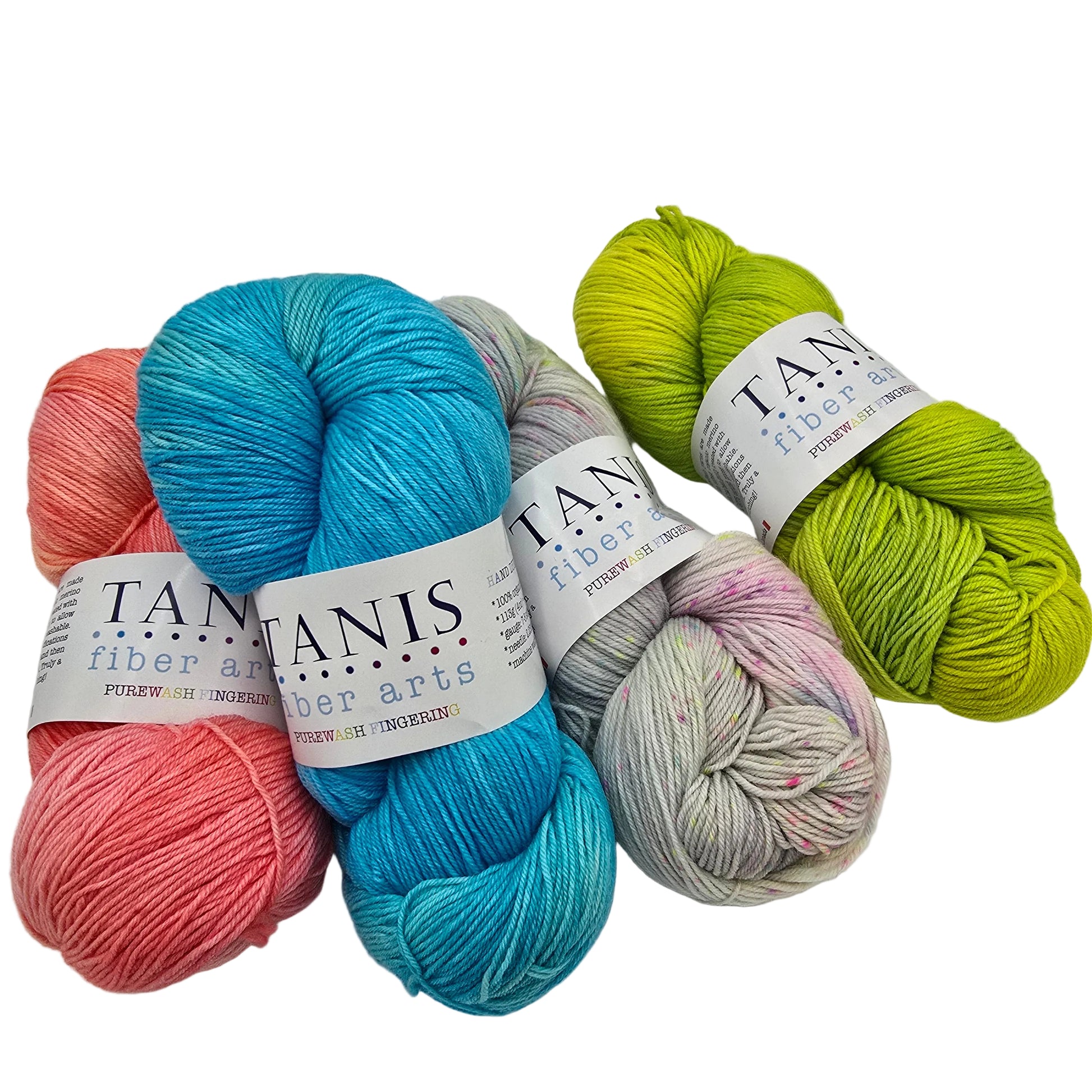 Five skeins of yarn in assorted colors arranged on a light gray background: lime green, variegated pink/gray, turquoise blue, coral pink, and peach. Each skein has a white paper label with the brand name Tanis fiber arts visible.