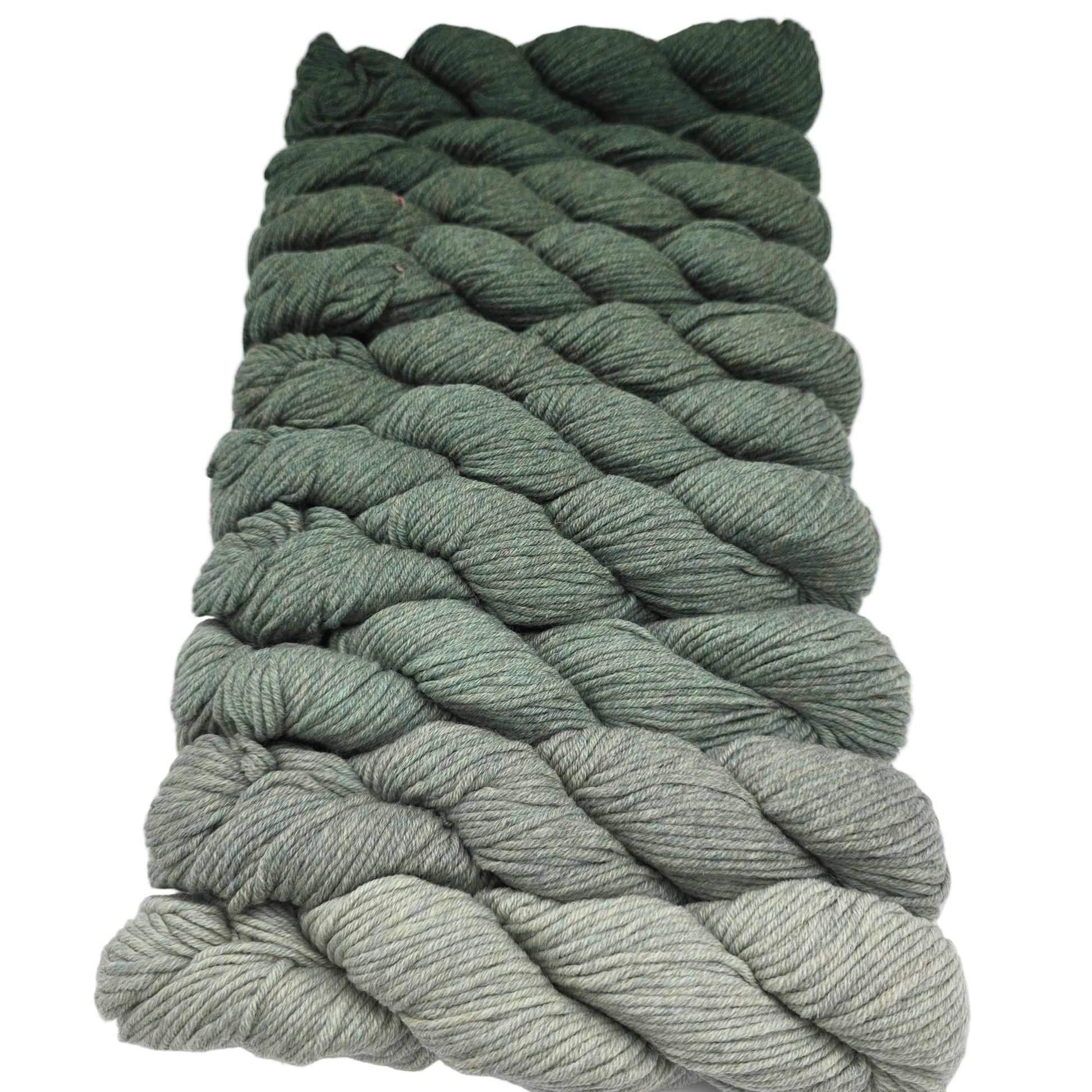 Image of a bundle of 10 skeins of yarn in a gradient from light to dark green in a color called juniper by the brand purl soho with labels on a white background.