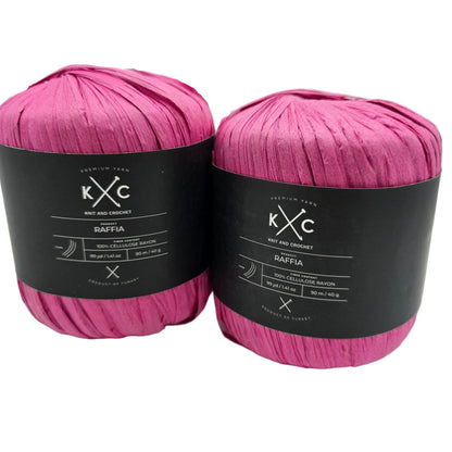 Image of two flat pull skeins of Raffia by K+C in the color Pink LT with labels on a white background.