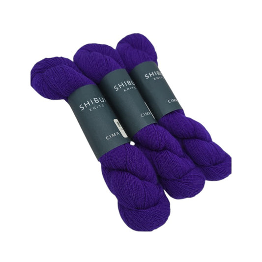 Three skeins of dark purple Shibui_Knits yarn in color called Tyrian yarn with Shibui Knits labels on a white background