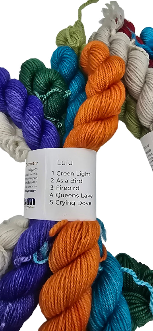 Image of multiple different colored mini skeins of Smooshy Cashmere by Dream yarn in color package named Lulu with label on white background