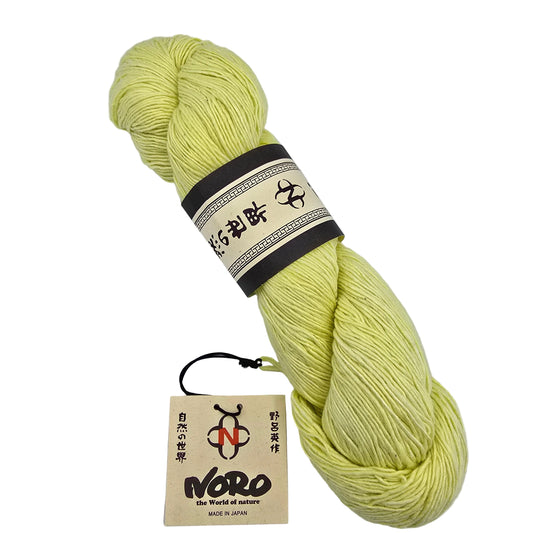 A skein of Sonata_yarn by_Noro_-in Color_33 a pale yellow yarn with a dark brown and cream paper label on a white background.
