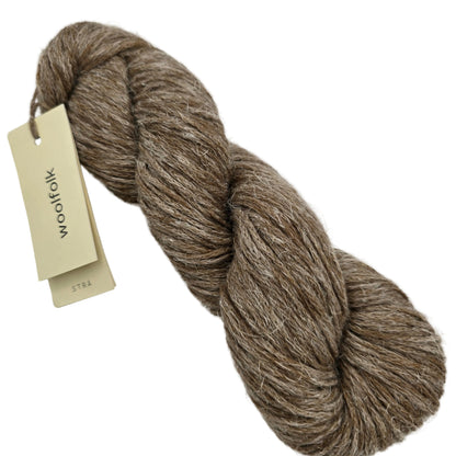 Image of a single skein of Stra by Woolfolk yarn in color S3 with label on a white background.