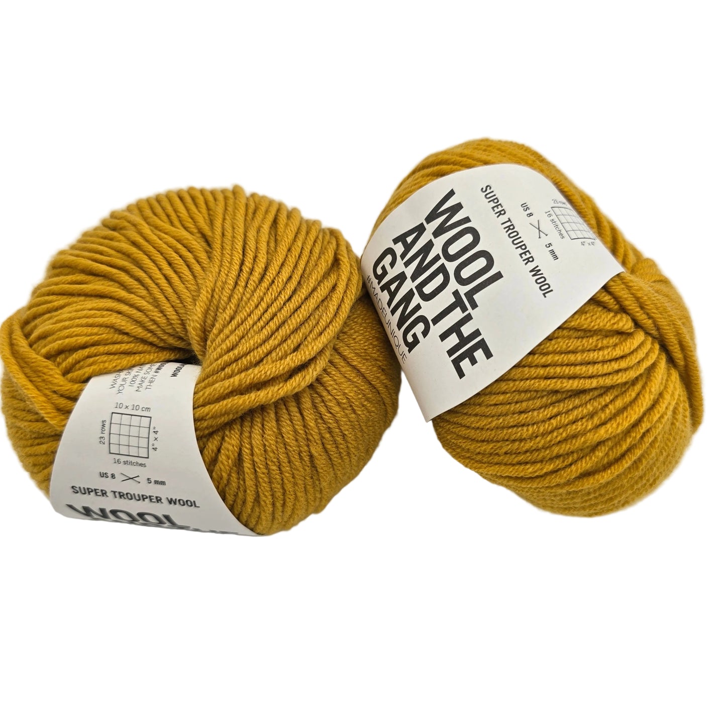 Image of two balls of Super Trouper Wool (The One Merino Wool) Yarn by Wool and Gang in the color Mustard Sally with labels on a white background.
