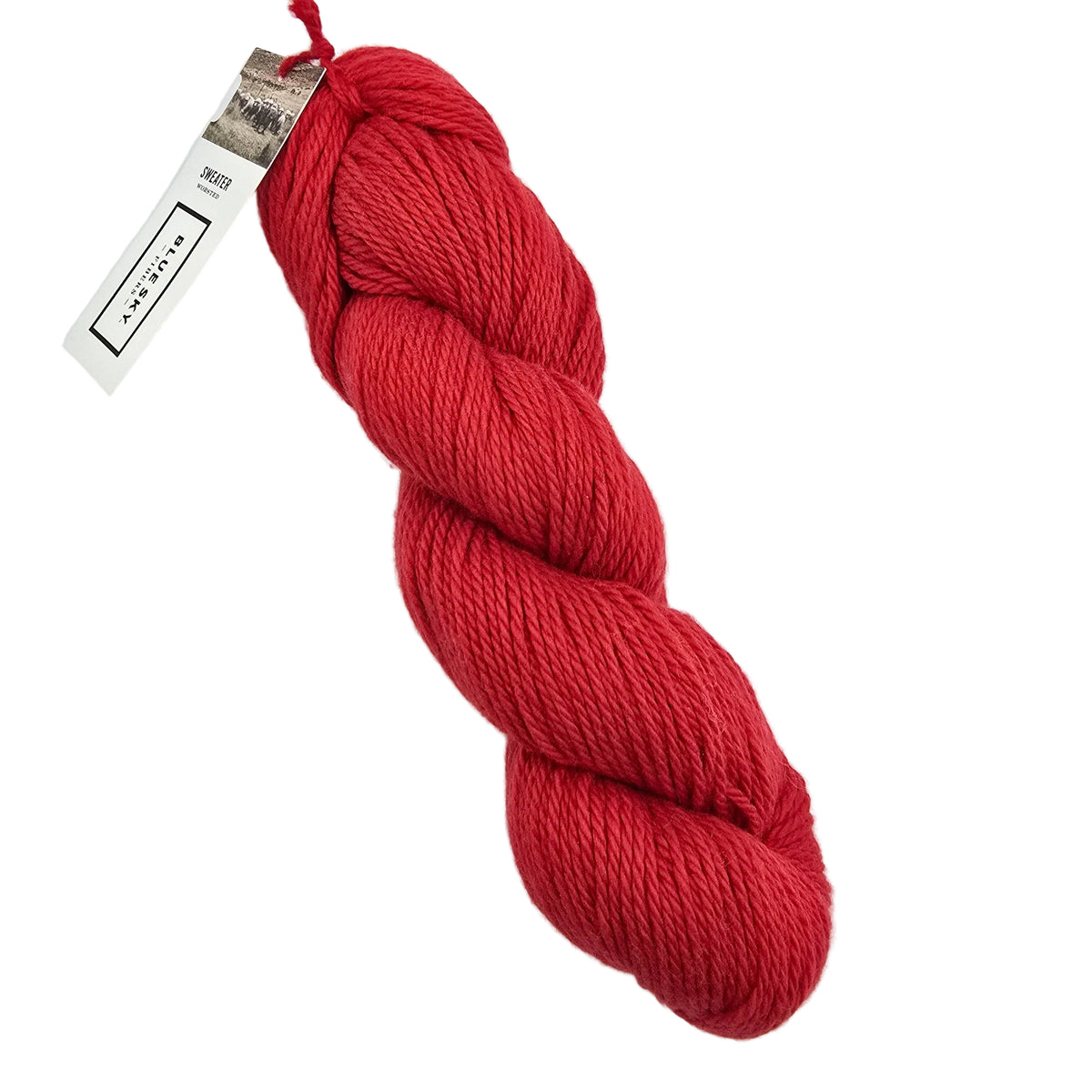 A skein of Sweater Worsted Yarn by Blue Sky Fibers in the color Barn a red yarn with a paper label attached, photographed on a clean white background.