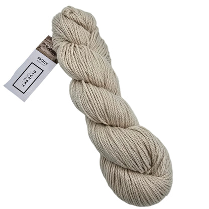 A skein of Sweater Worsted Yarn by Blue Sky Fibers in the color Sweet roll a taupe  yarn with a paper label attached, photographed on a clean white background.