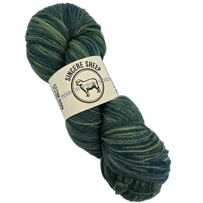 Image of a single hank of Terroir Series Cormo Sport Yarn by Sincere Sheep -in the color Suerte with label on a white background.