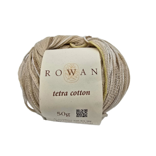 A ball of Rowan Tetra Cotton yarn in color 3  a light beige color, wrapped with a cream-colored paper label showing the brand name 'ROWAN' and product details, set against a plain light gray background.