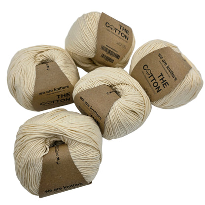 Image of multiple balls of The Cotton Yarn by We Are Knitters in Natural with labels on a white background.