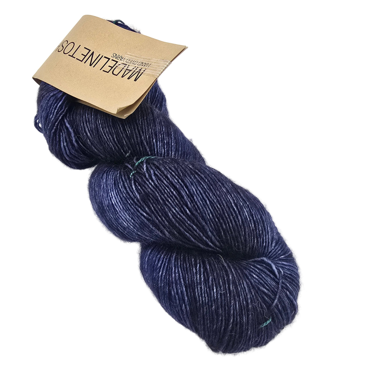 A single hank of Tosh_Merino_Light_Yarn_by_Madelinetosh_in the color Ink a dark navy blue yarn with a kraft paper label on a white background.