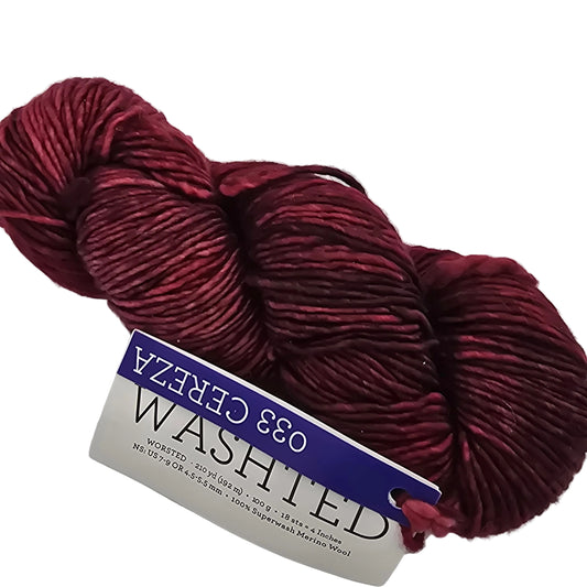 Image of a single skein of Washted by Malabrigo Yarn in Color 033 Cereza with label on white background.