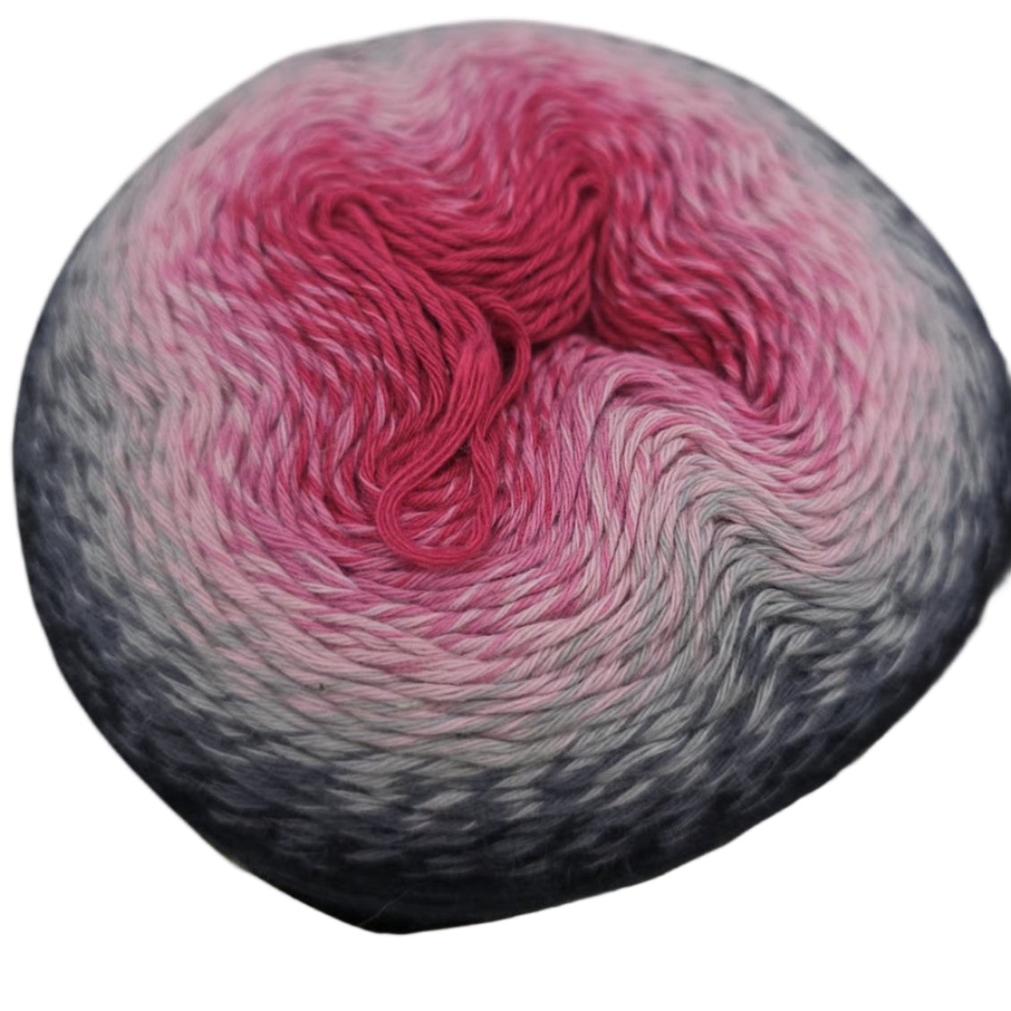 Close-up Image of one cake of gradient Whirl by Sheepjes yarn in the color night time bubbles, that transitions from black to white to pink on a white background.
