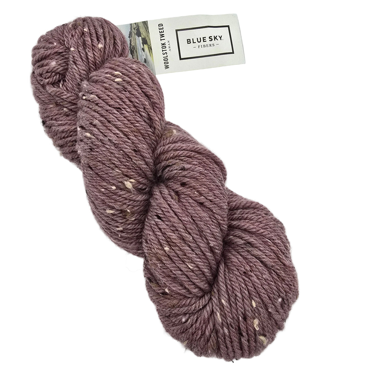A skein of dusty mauve wool yarn with flecks of cream and brown, featuring a paper label on a white background.