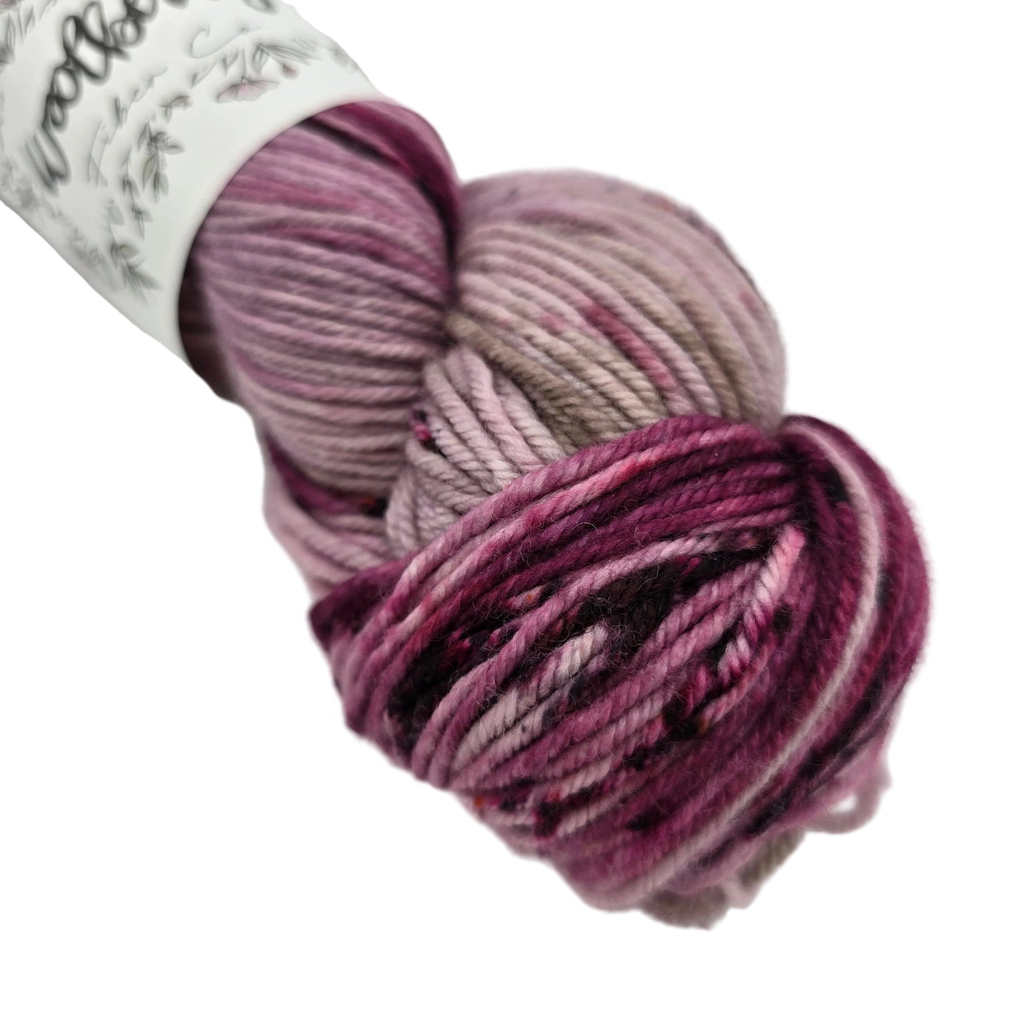 Close-up image of Berry DK yarn by Woolberry in the color Galentines Day with partial label on a white background.