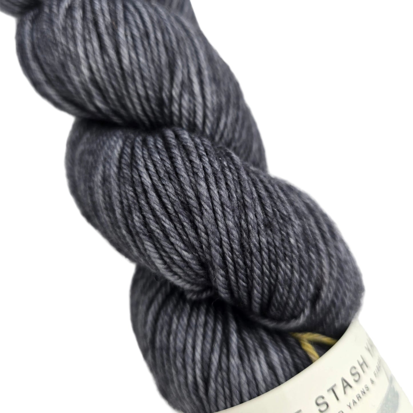 Close-up image  of DK_Tonal_Yarn_by_Must_Stash_Yarn in the color Night_Owl with partial label on a white backgorund.