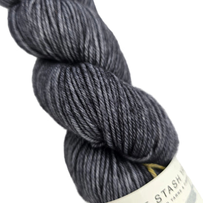 Close-up image  of DK_Tonal_Yarn_by_Must_Stash_Yarn in the color Night_Owl with partial label on a white backgorund.