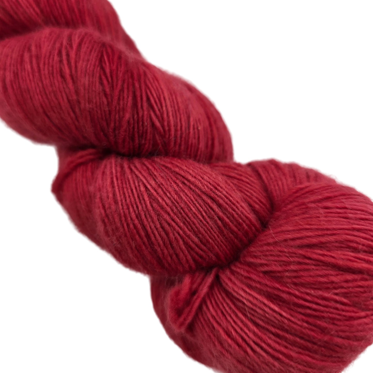 Close-up Image of single hank of Lace by Malabrigo Yarn in color 611 Ravelry Red on a white background.