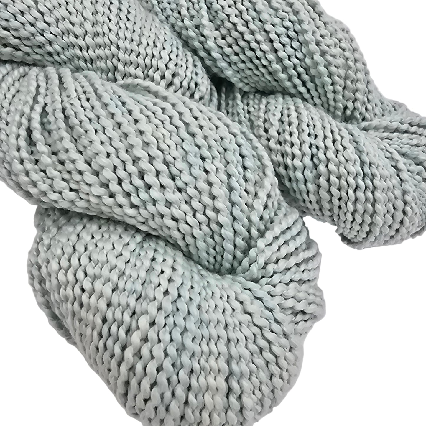 Close-up Image of skeins of Serif by Purl Soho yarn in the color turquoise tint which is a pale blue on a white background.