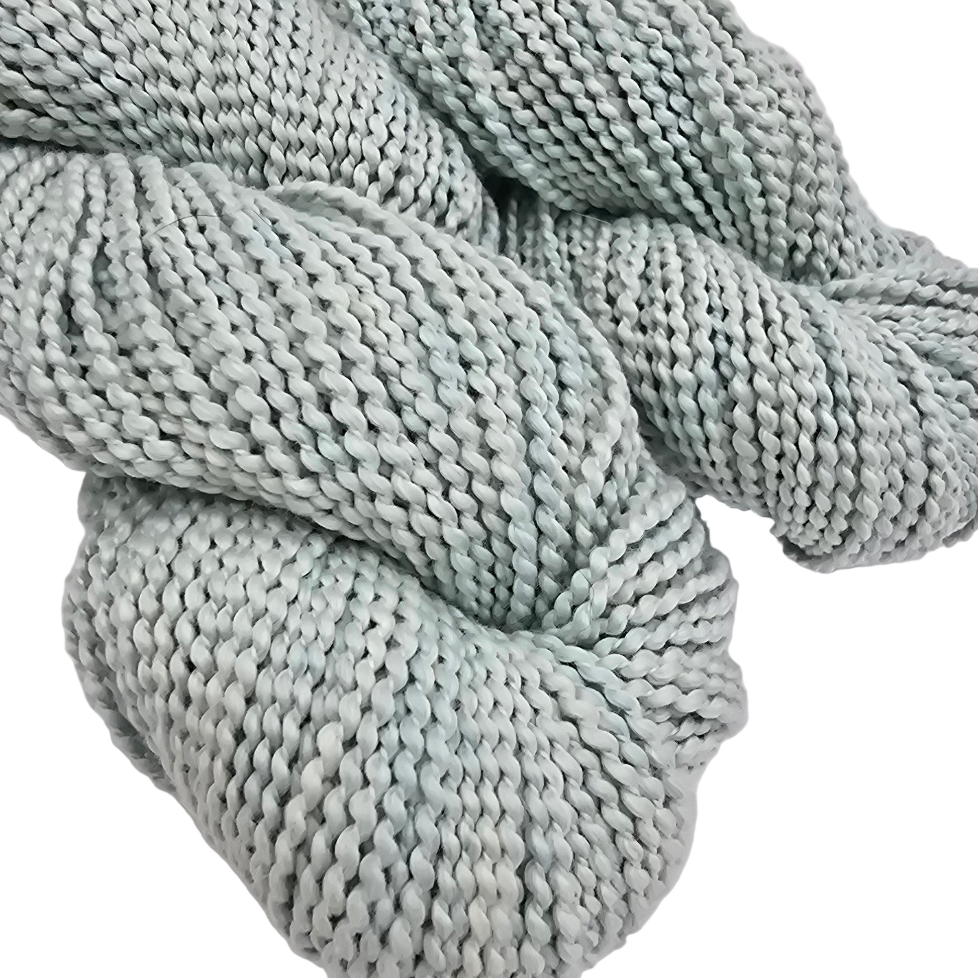 Close-up Image of skeins of Serif by Purl Soho yarn in the color turquoise tint which is a pale blue on a white background.